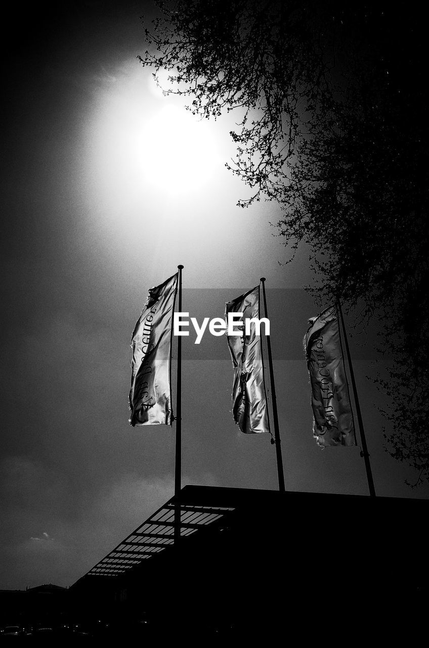 LOW ANGLE VIEW OF FLAGS HANGING ON BUILDING