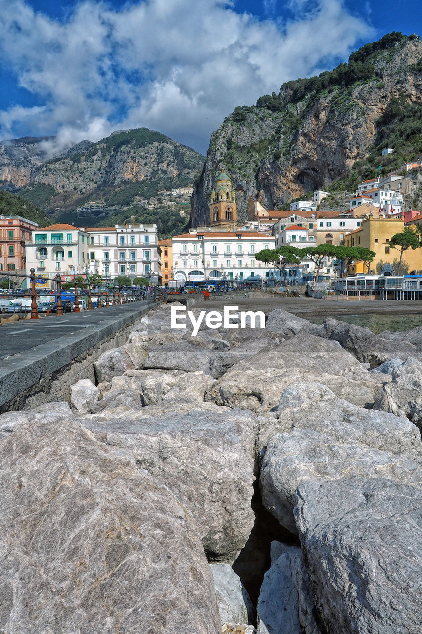 Town by sea and mountains against sky