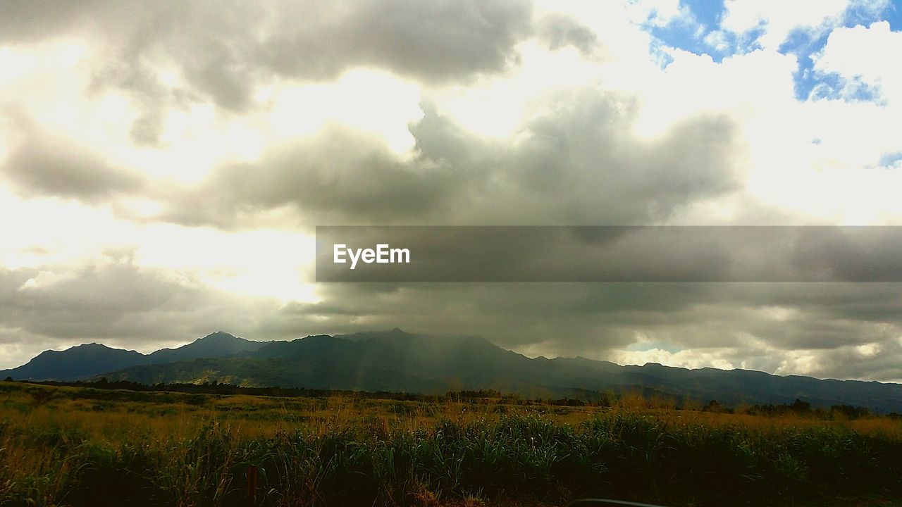 SCENIC VIEW OF MOUNTAINS AGAINST CLOUDY SKY