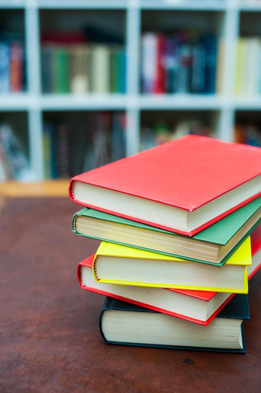 Colorful books stacked on desk in library