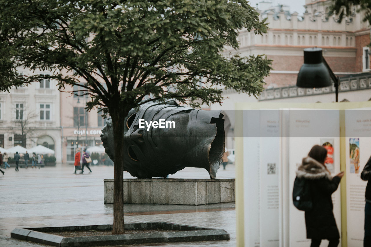 REAR VIEW OF STATUE AND BUILDING IN CITY