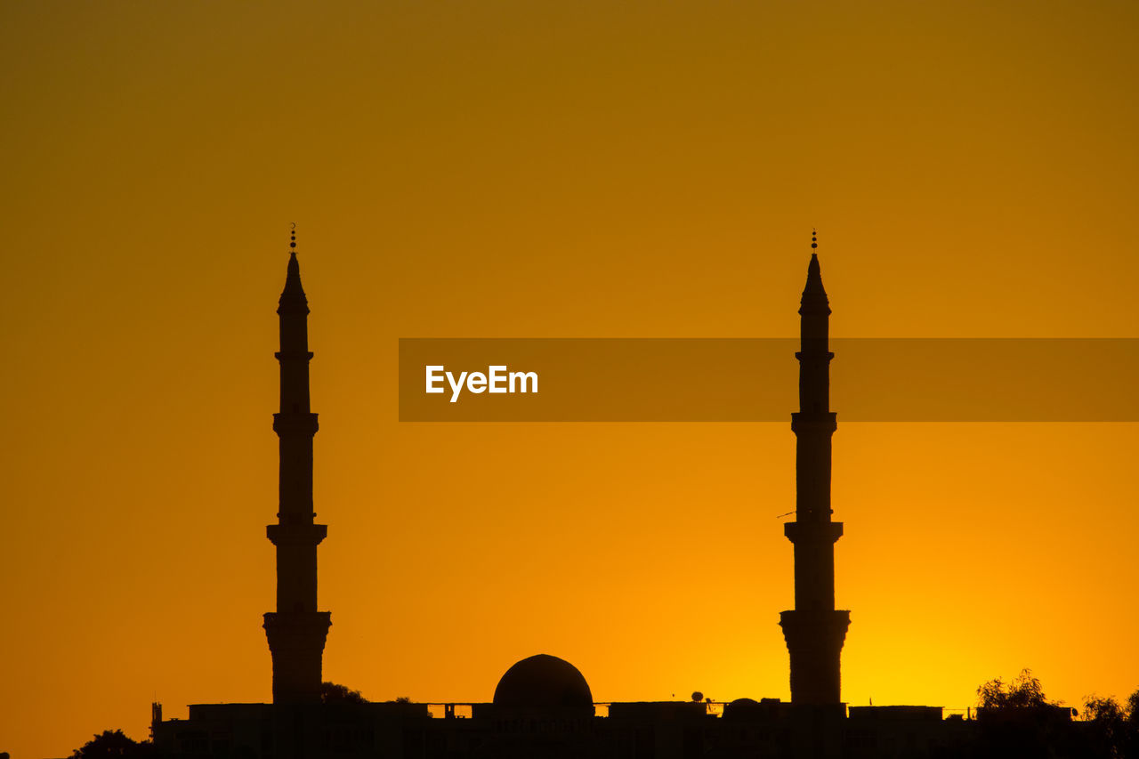 Silhouette of building against sky during sunset