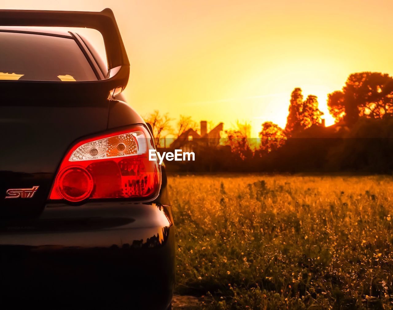 CLOSE-UP OF CAR AGAINST SUNSET