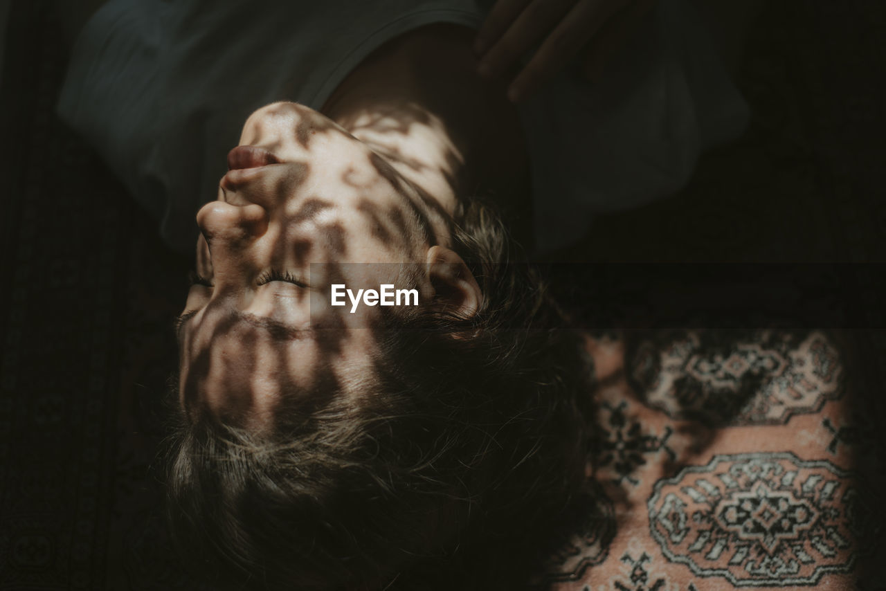 High angle view of young woman sleeping on bed