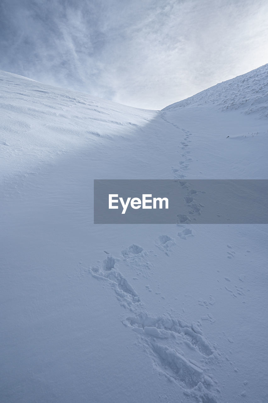 Aerial view of snowcapped mountains against sky