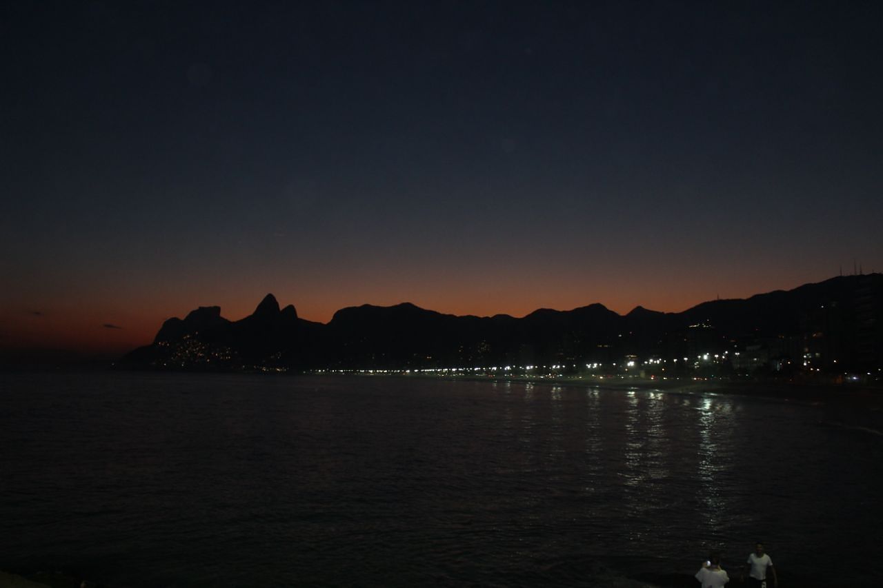 SCENIC VIEW OF SEA BY SILHOUETTE MOUNTAIN AGAINST SKY