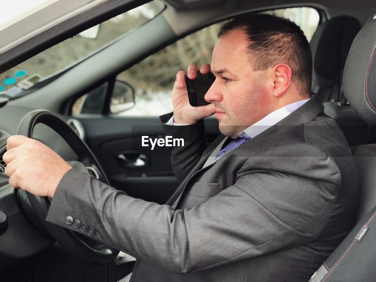 Businessman talking on mobile phone while sitting in car