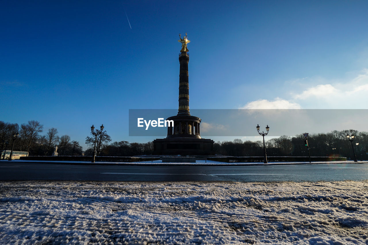 Low angle view of victory column against sky during winter