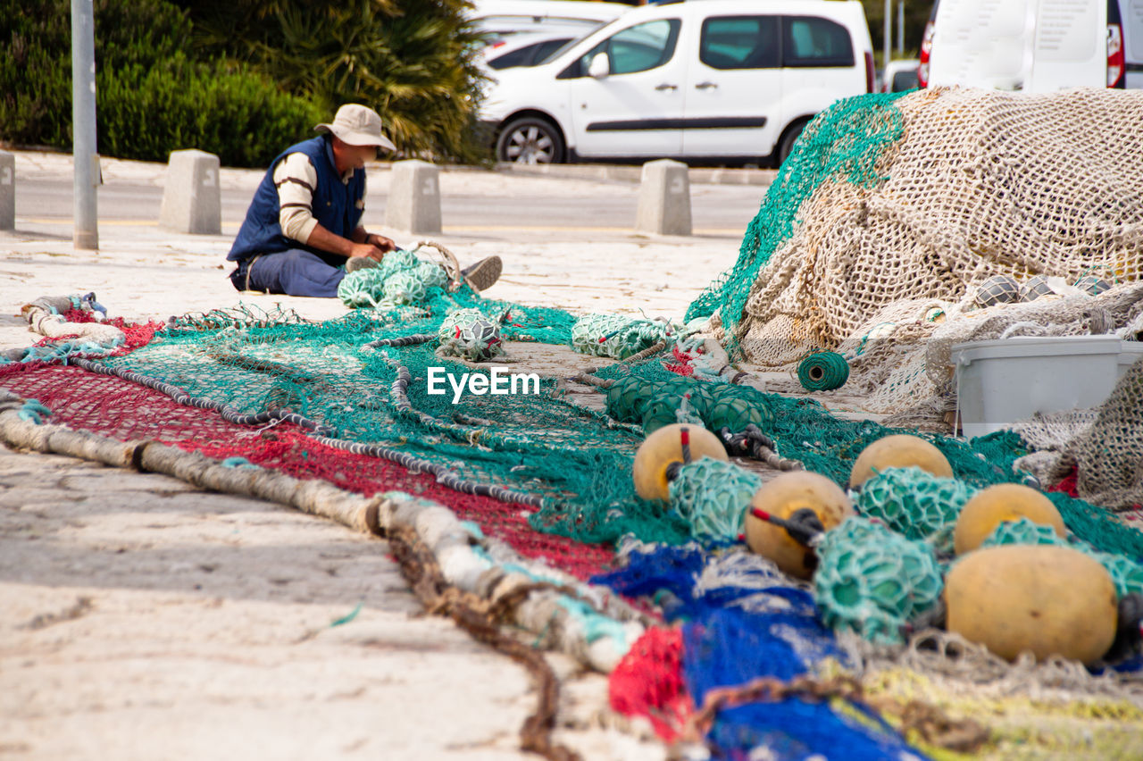 FULL LENGTH OF MAN WORKING WITH FISHING NET