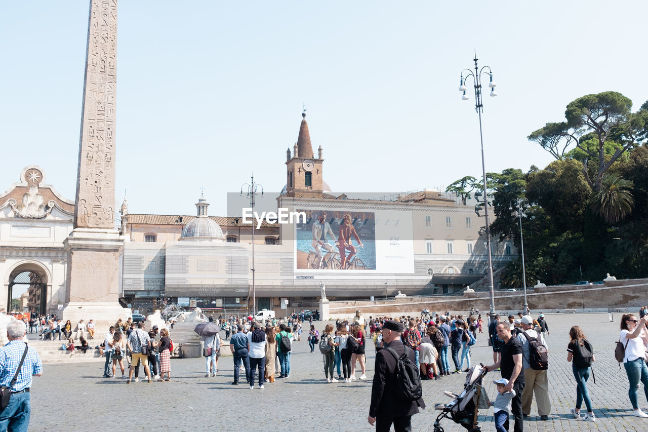 GROUP OF PEOPLE IN FRONT OF BUILDINGS