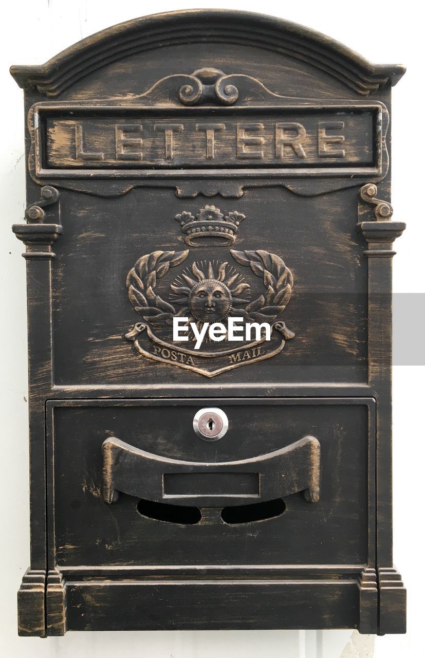 Close-up of old mailbox against white background