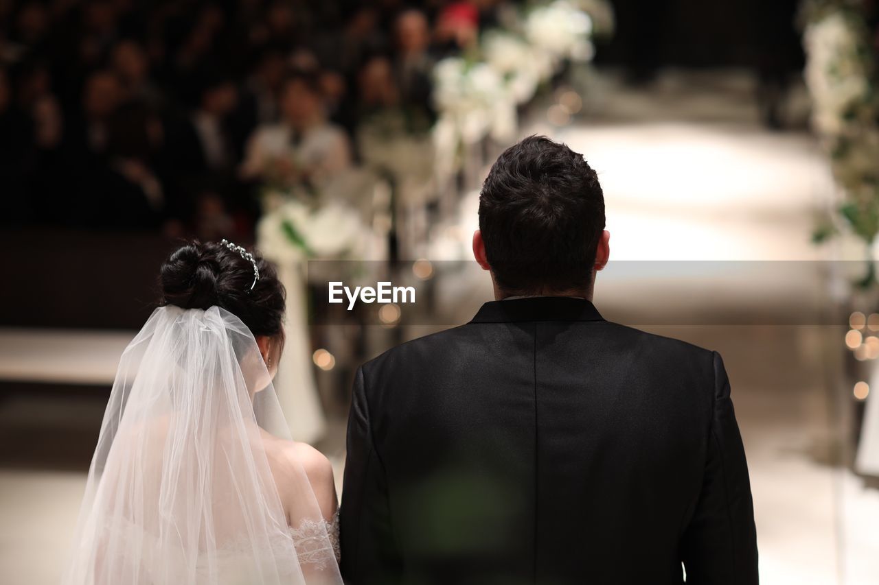 Rear view of wedding couple standing in church