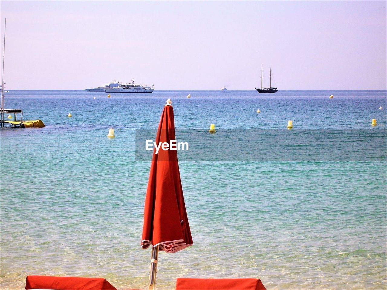 SAILBOAT ON SEA SHORE AGAINST CLEAR SKY