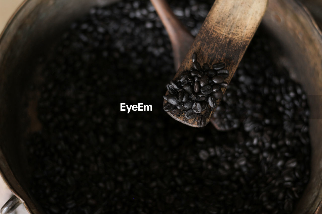 HIGH ANGLE VIEW OF HAND HOLDING COFFEE BEANS