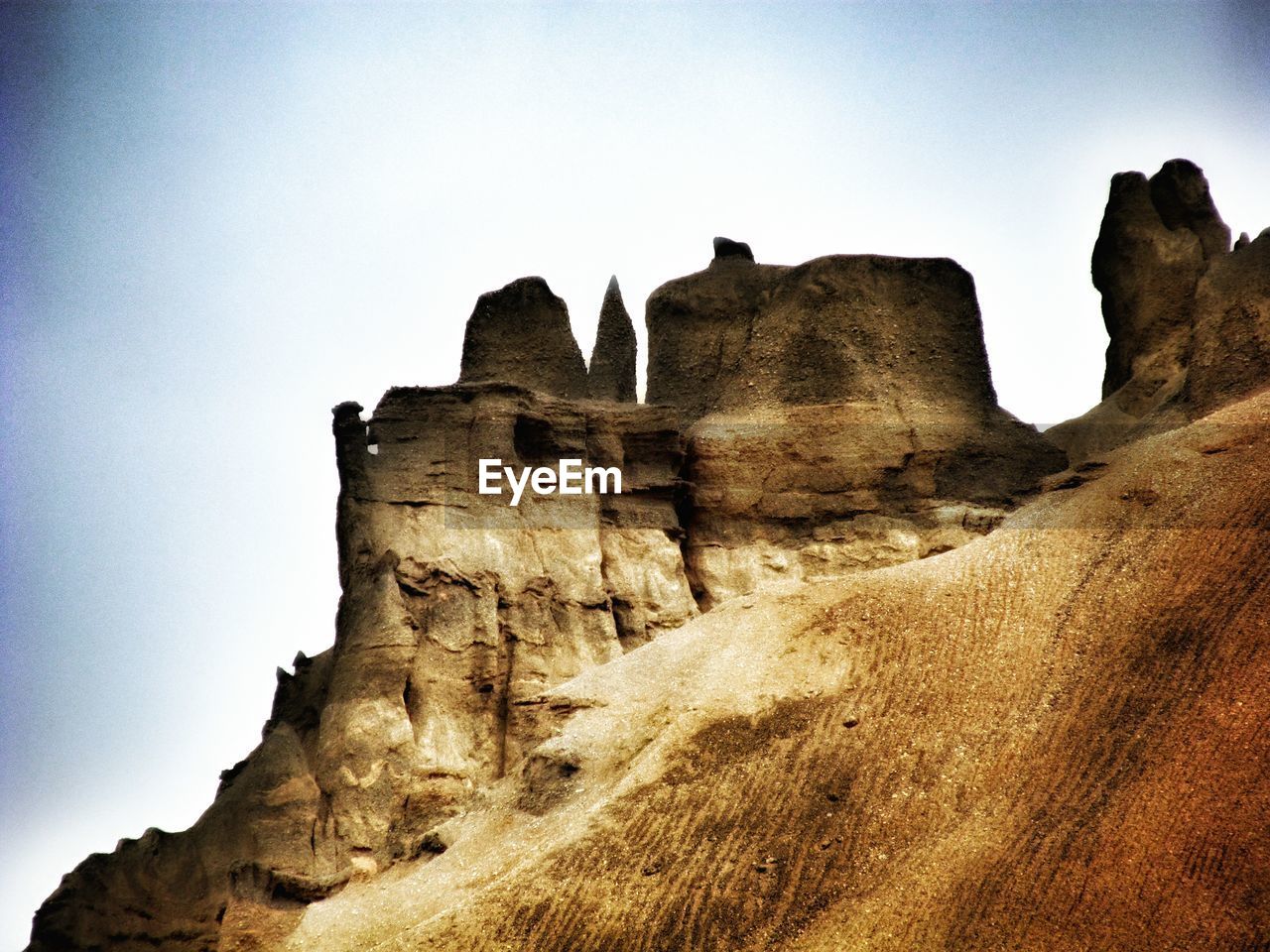 Low angle view of rocky peak against clear sky