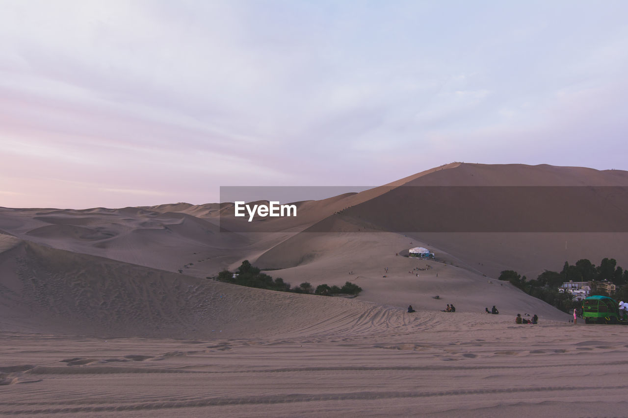 View of sand in desert with tourists