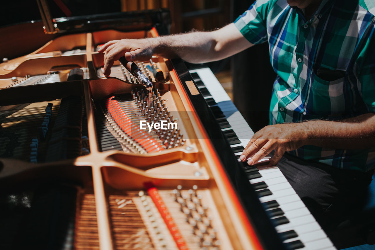 Midsection of man playing piano