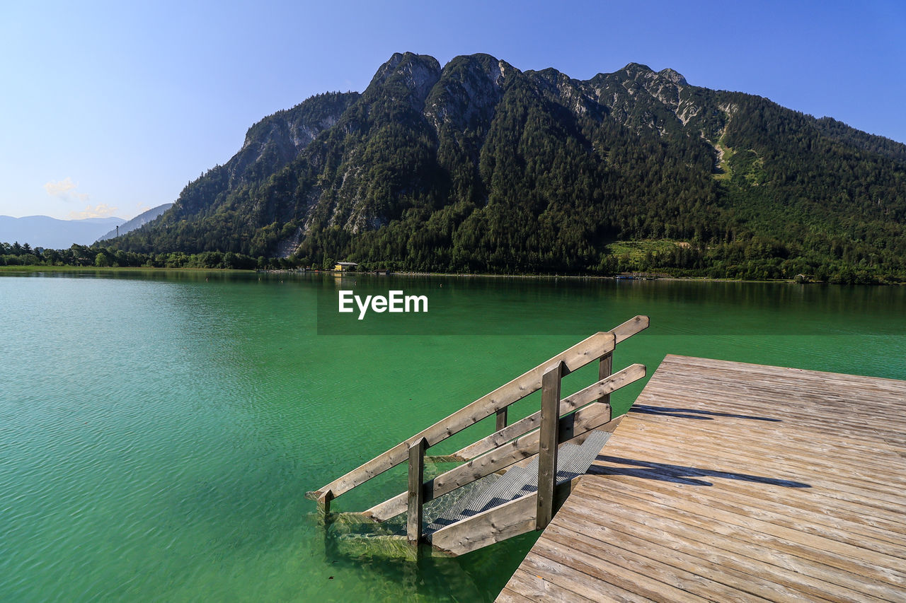 PIER OVER LAKE AGAINST MOUNTAINS