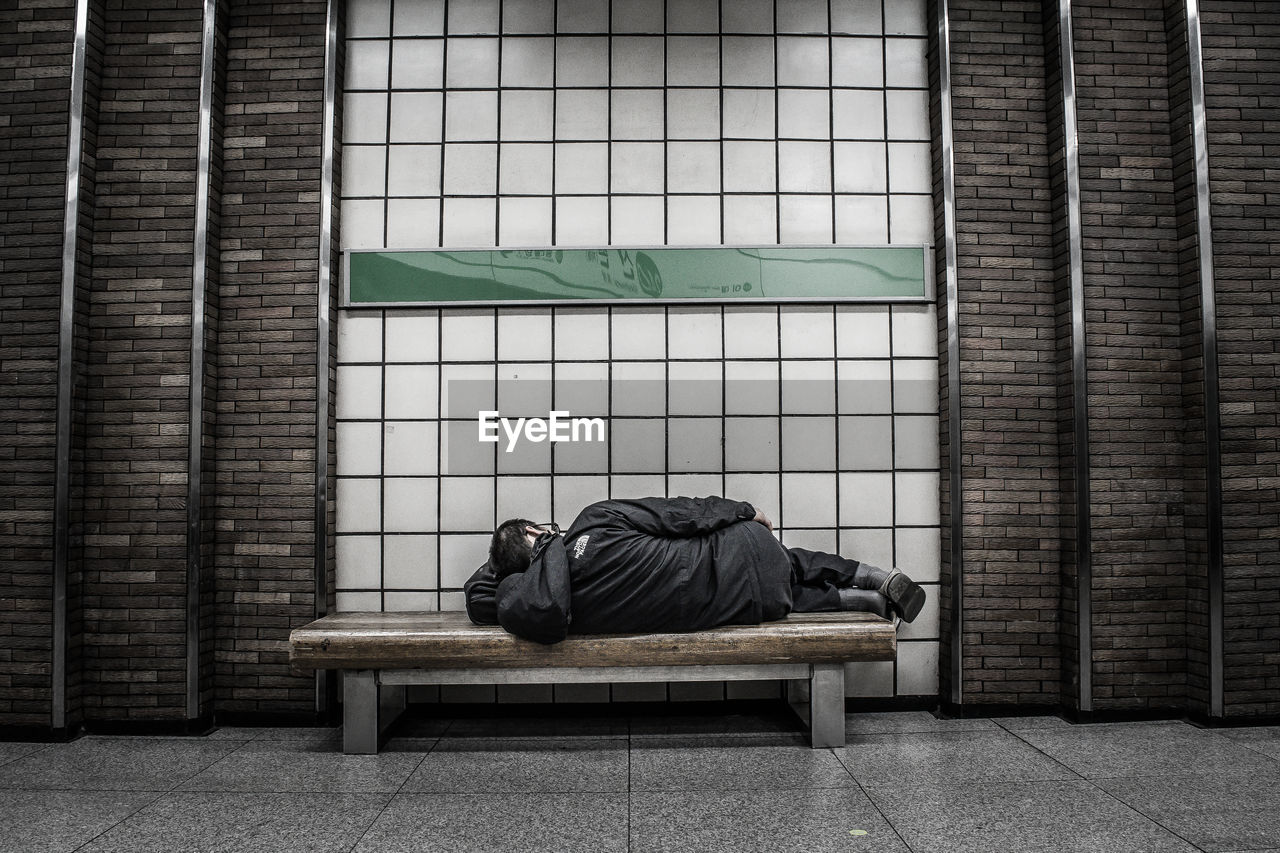 MAN LYING ON TILED FLOOR IN ROOM