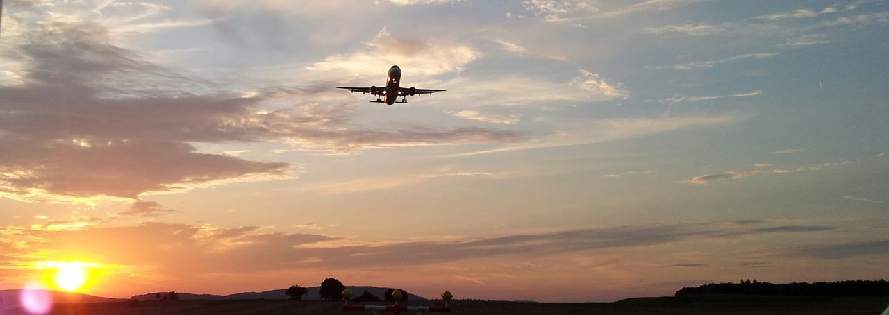 Low angle view of airplane against sunset