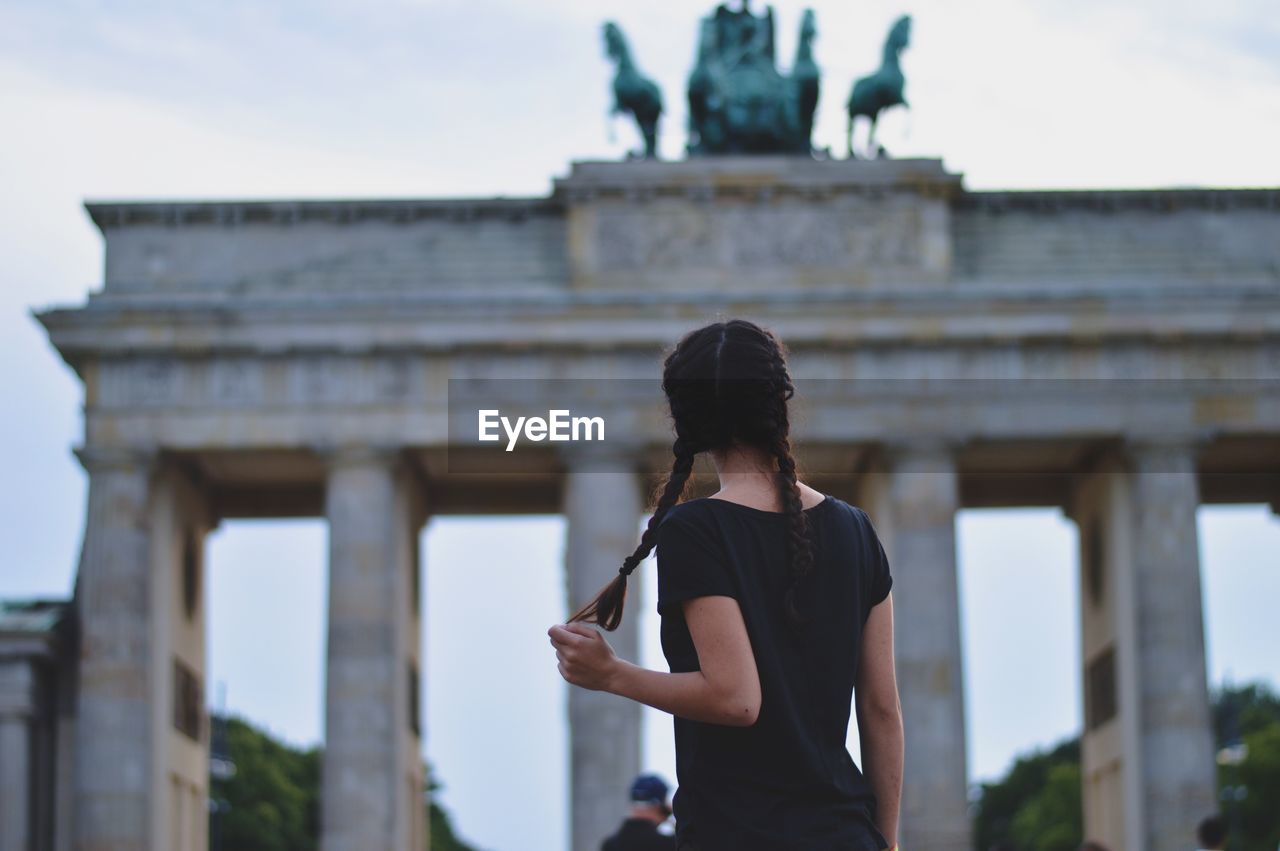 Rear view of woman standing in front of brandenburg gate