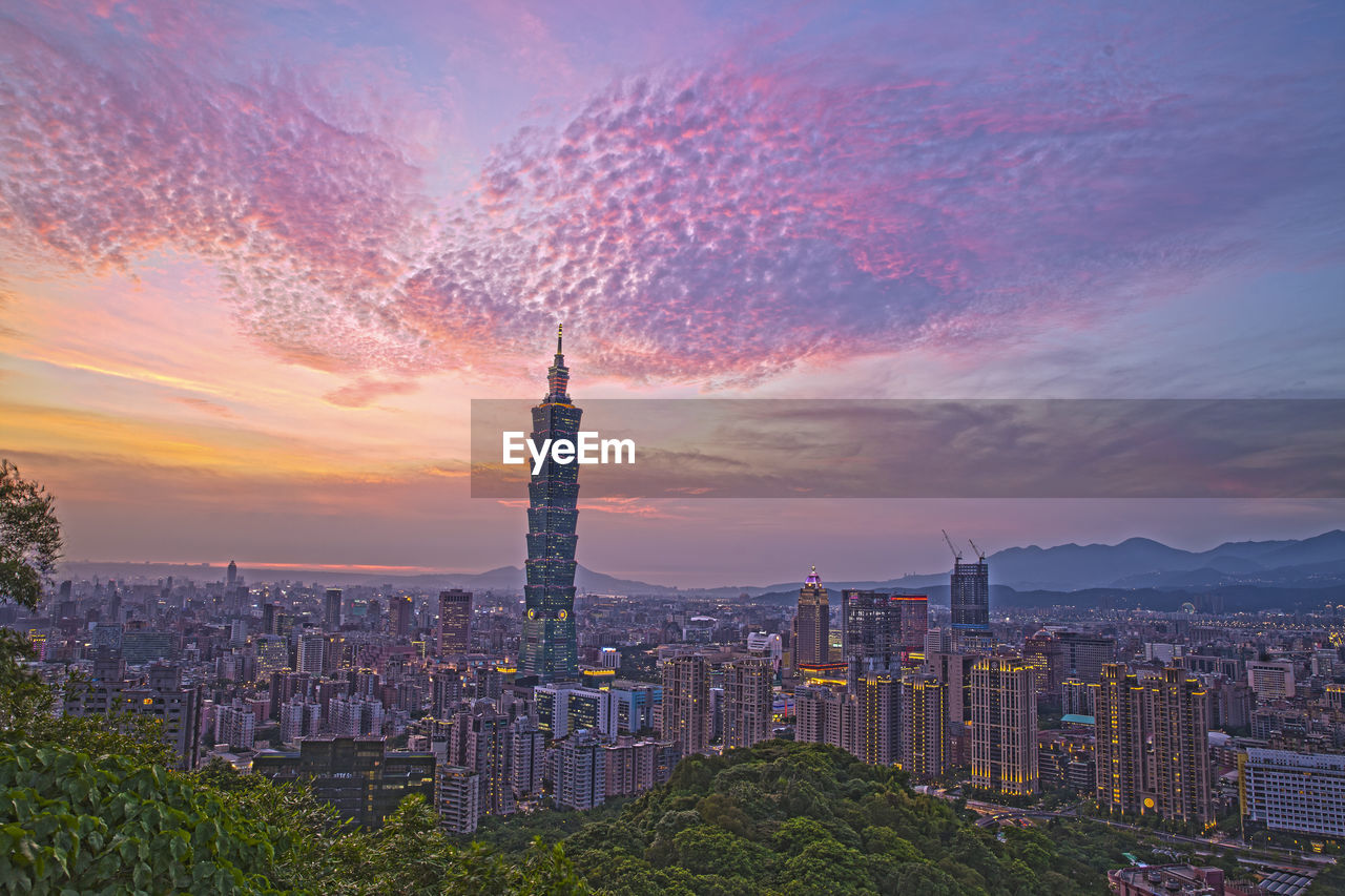 High angle view of city lit up at sunset