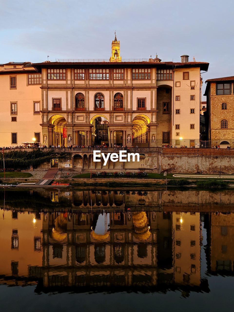 REFLECTION OF BUILDINGS IN WATER AT DUSK