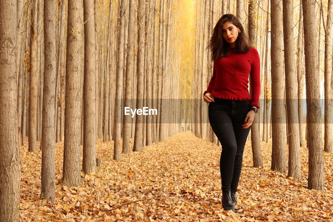 Full length of woman standing in park during autumn