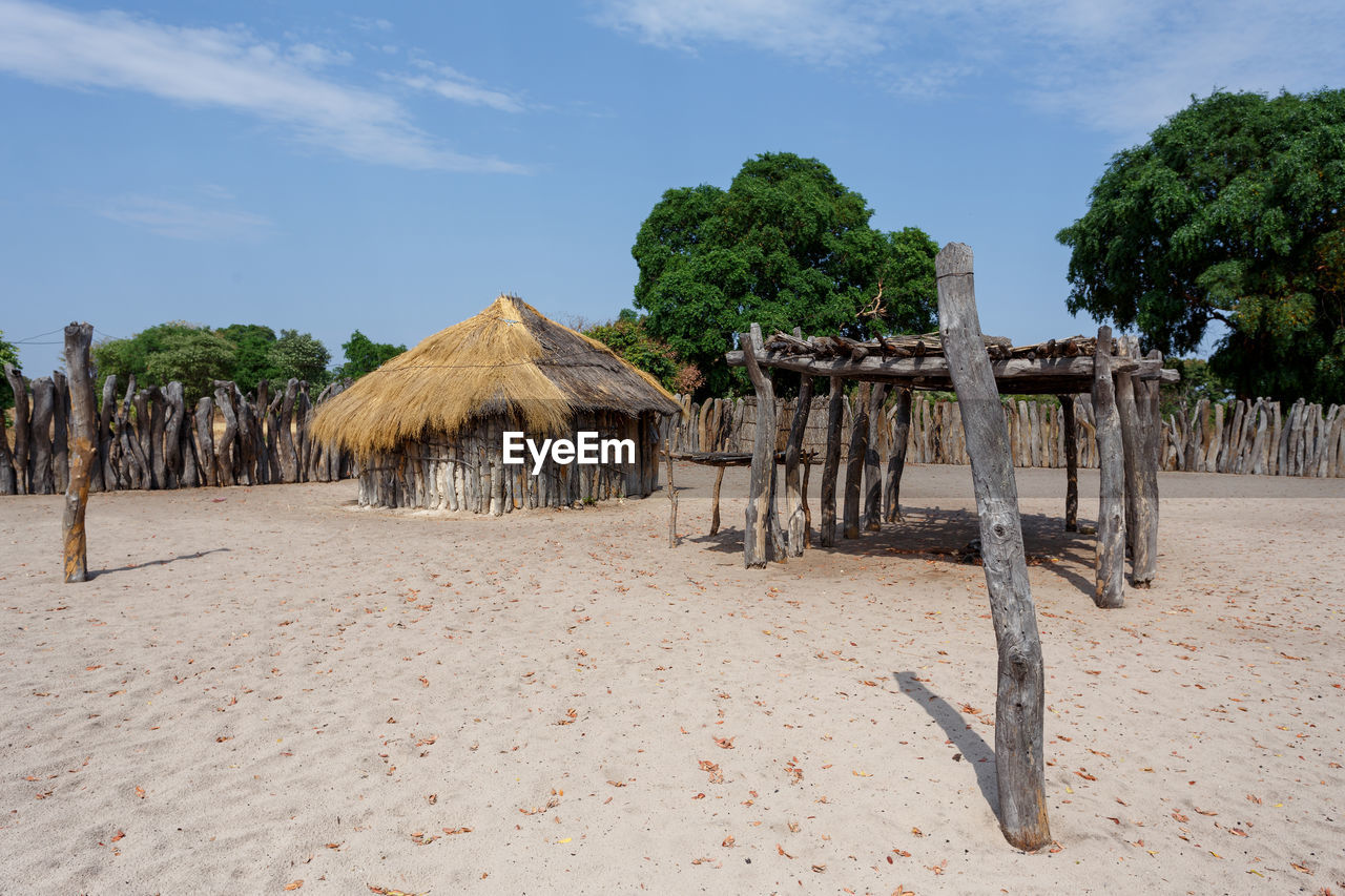 WOODEN HUT ON BEACH AGAINST TREES