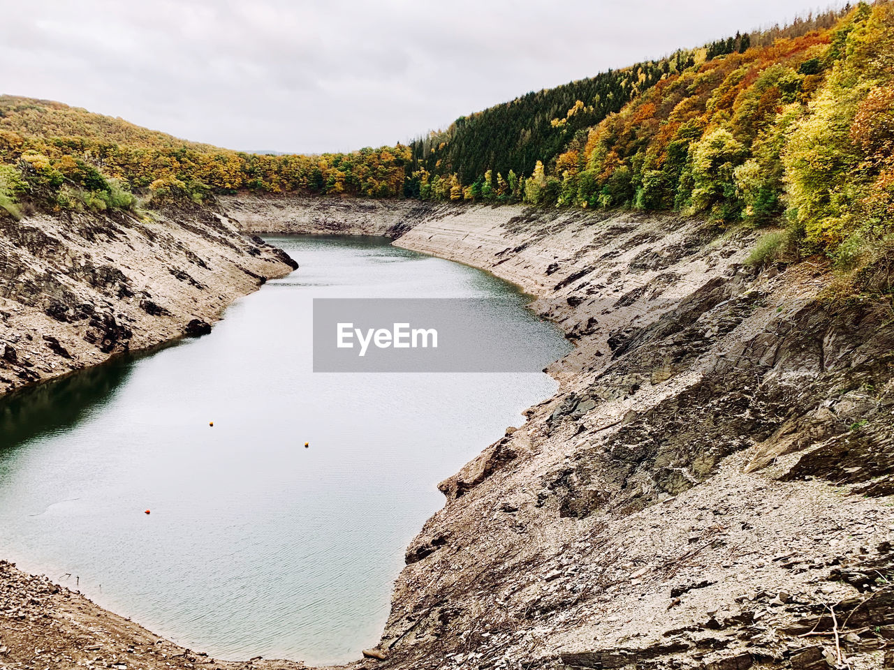 HIGH ANGLE VIEW OF RIVER AMIDST ROCKS AGAINST SKY