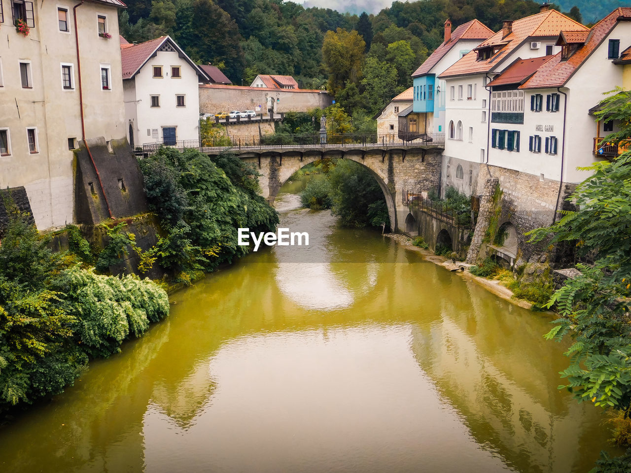 ARCH BRIDGE OVER RIVER BY BUILDINGS