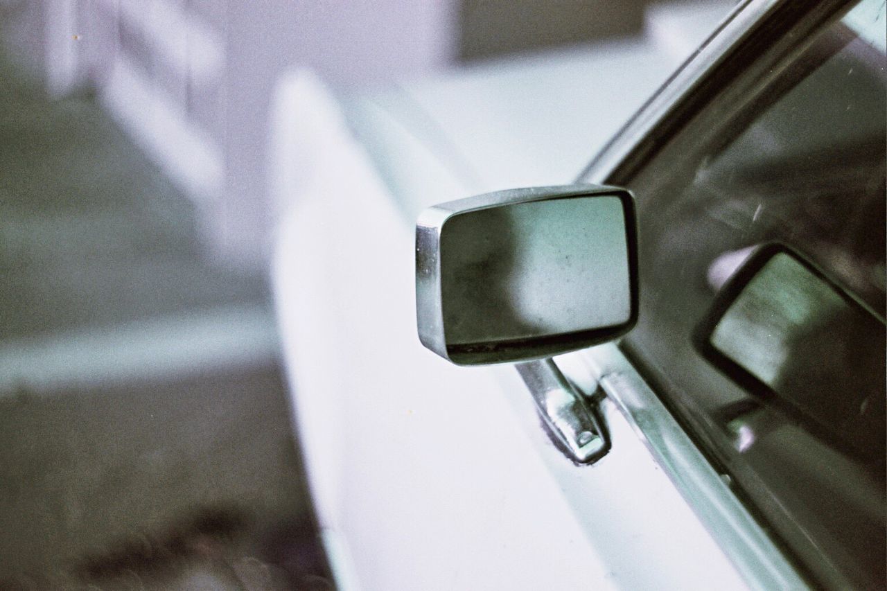 CLOSE-UP OF VINTAGE CAR ON SIDE-VIEW MIRROR OF VEHICLE