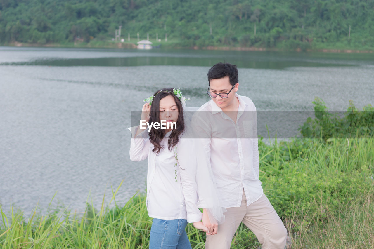 YOUNG COUPLE STANDING ON WATER