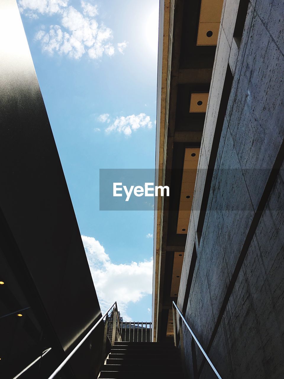 Low angle view of steps amidst buildings against sky