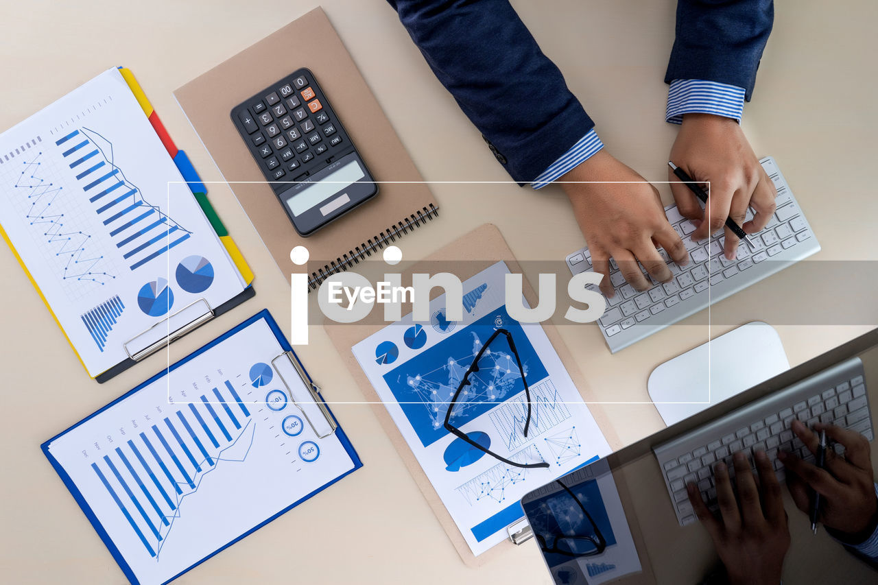 Directly above shot of businessman working over graph on table