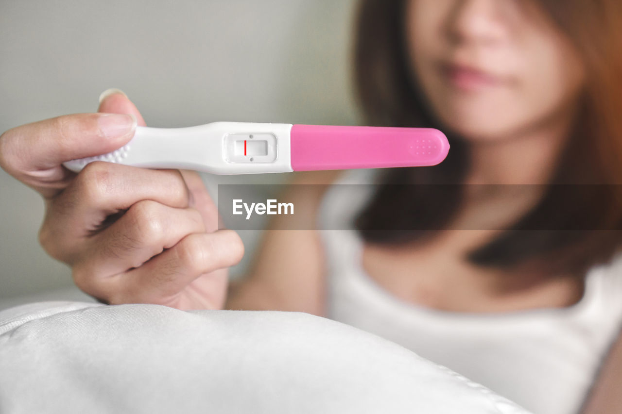 Close-up of woman holding pregnancy test equipment