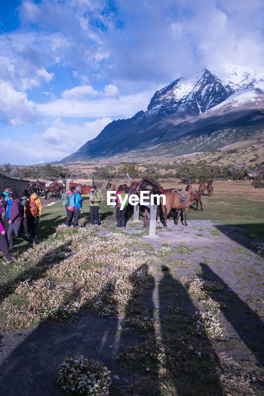 Group of people on mountain against sky