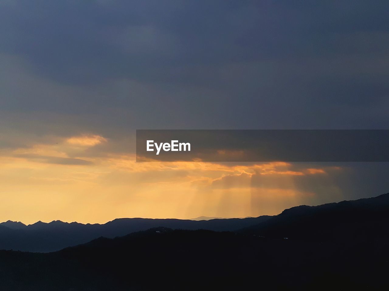 SCENIC VIEW OF SILHOUETTE MOUNTAINS AGAINST DRAMATIC SKY