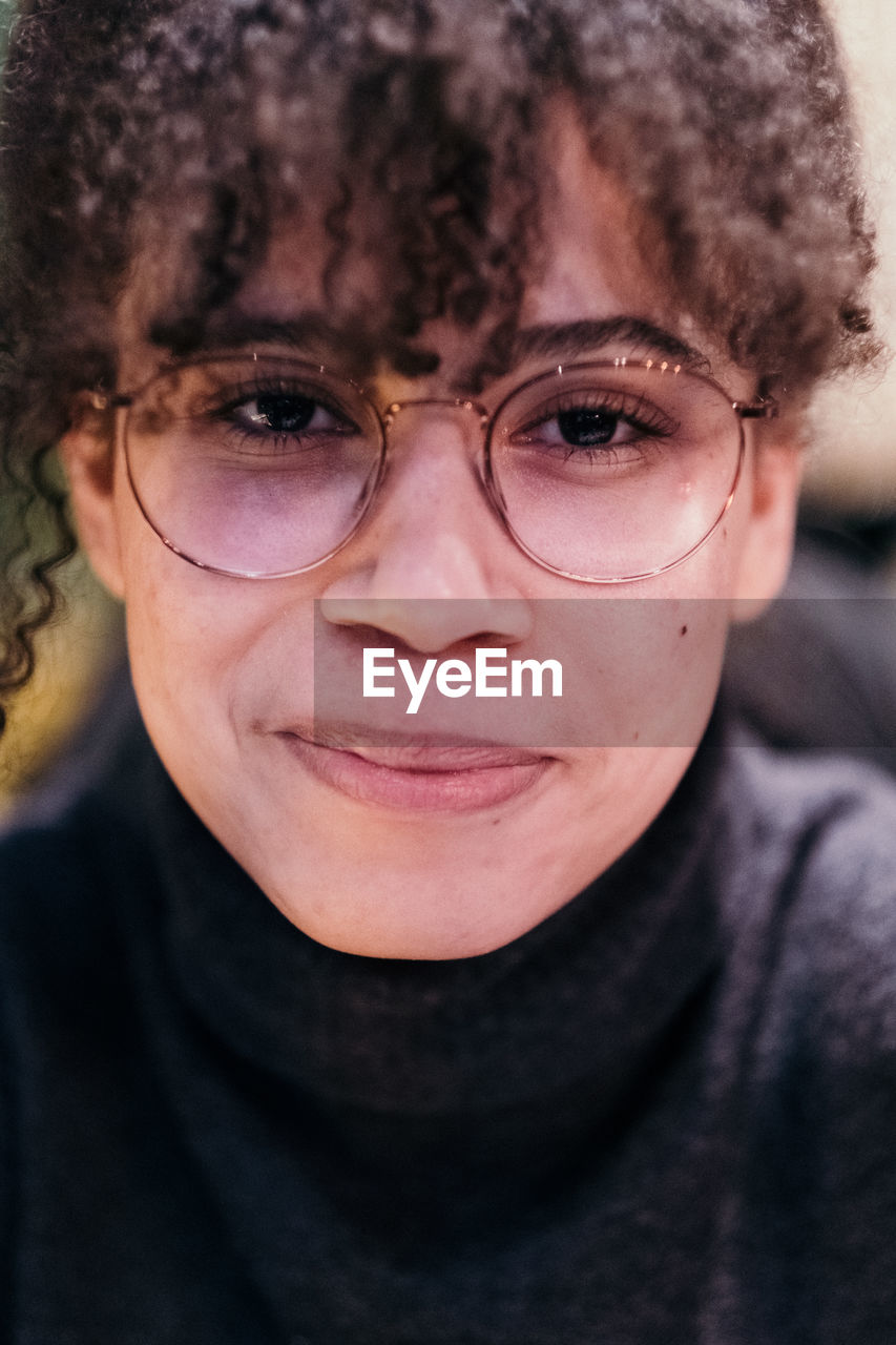 Close-up portrait of smiling teenage girl wearing eyeglasses