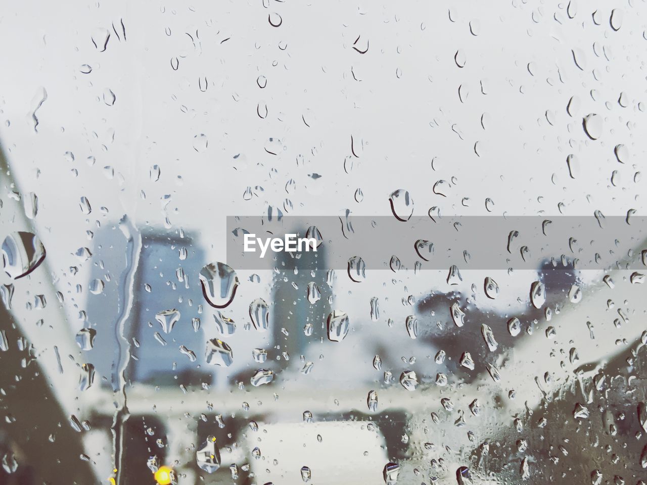 Water drops on glass window against sky