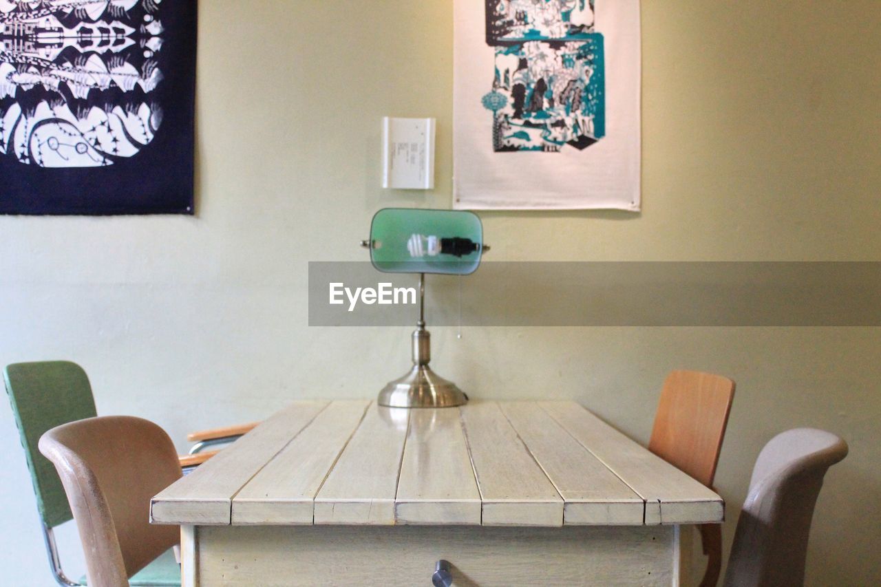 Electric lamp on table amidst chairs in cafe