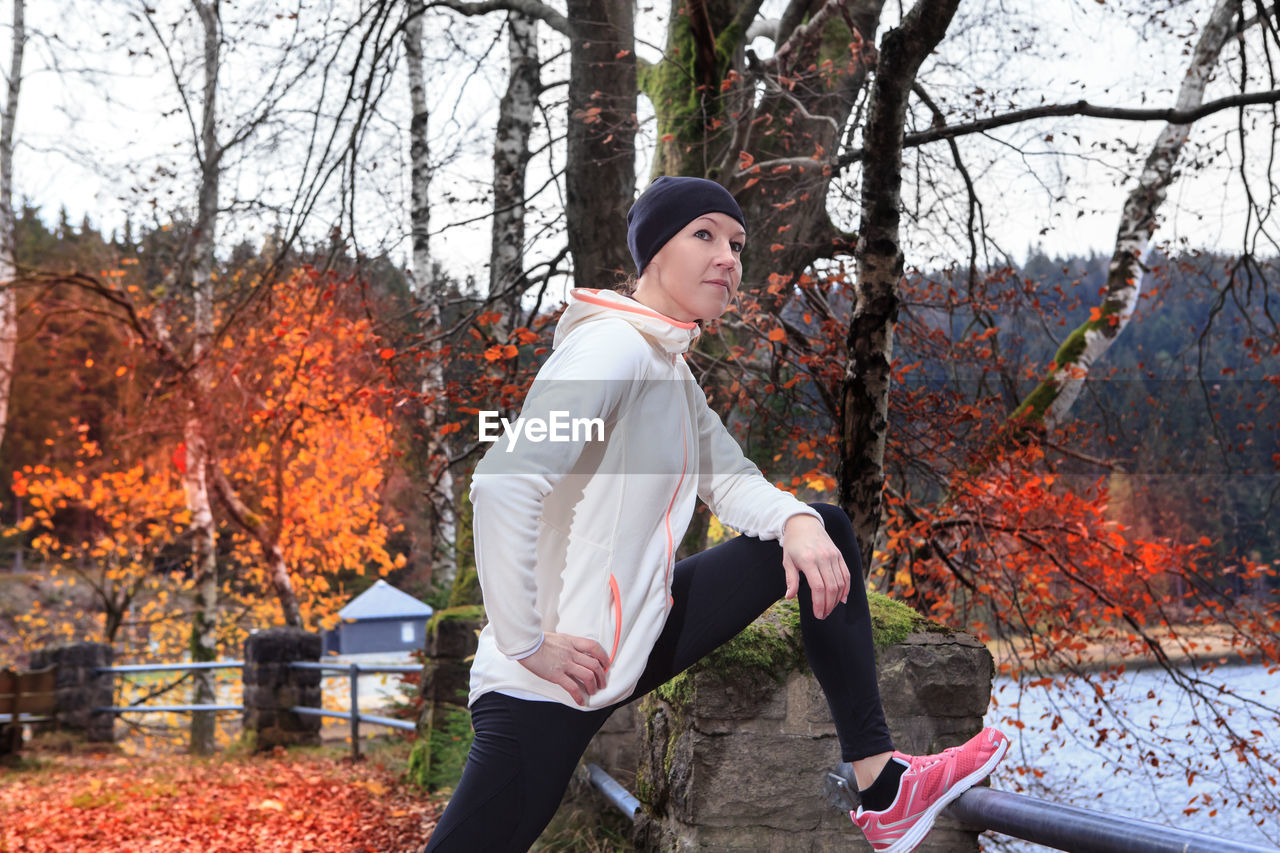 Woman exercising by lake 