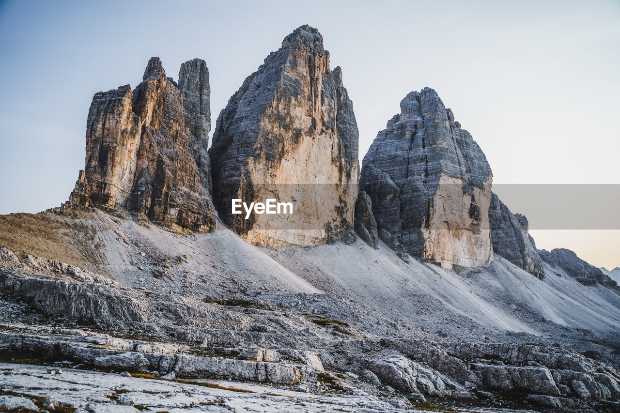 LOW ANGLE VIEW OF ROCKS ON MOUNTAIN AGAINST SKY