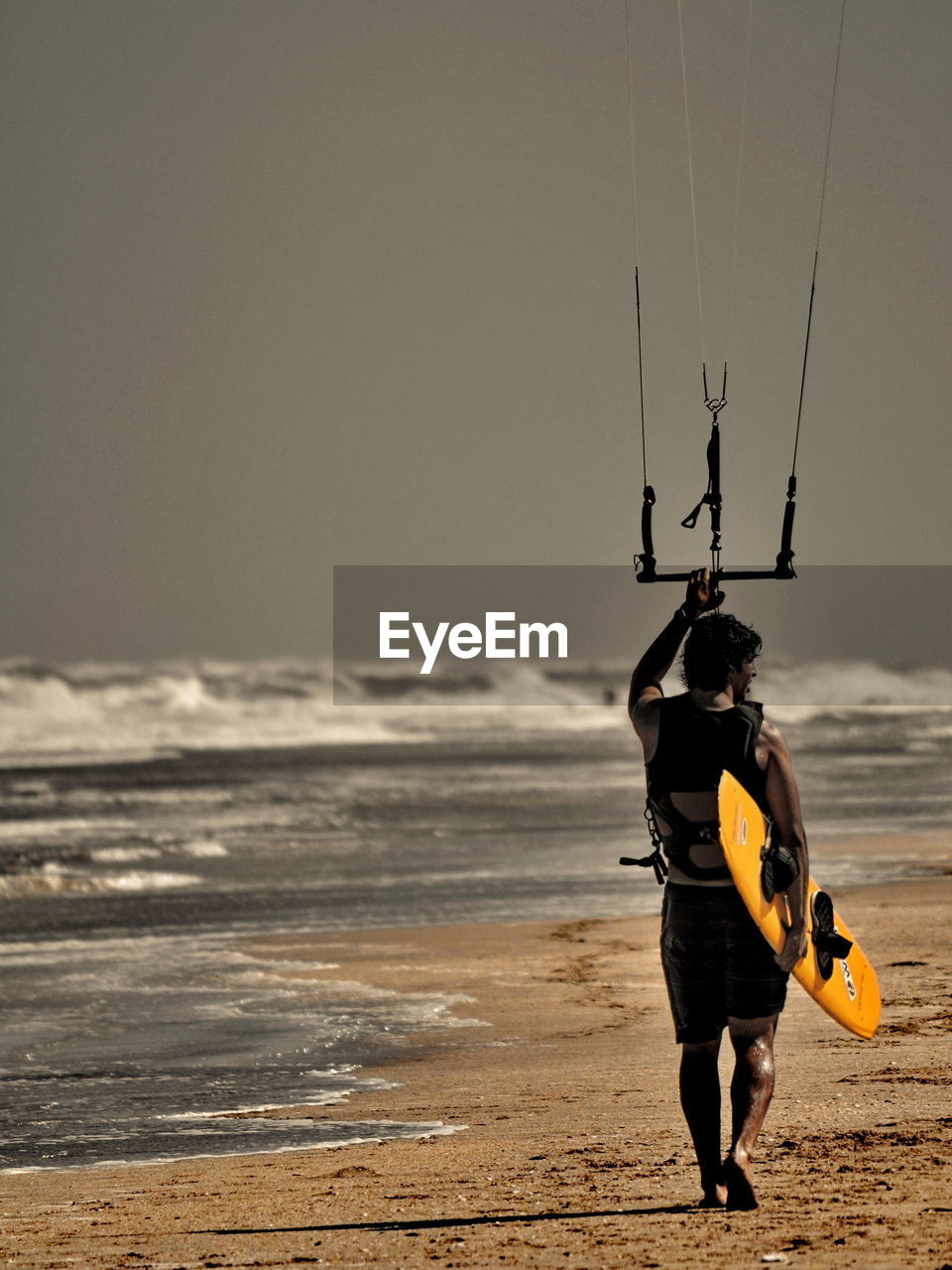 FULL LENGTH OF MAN WALKING ON BEACH AGAINST CLEAR SKY