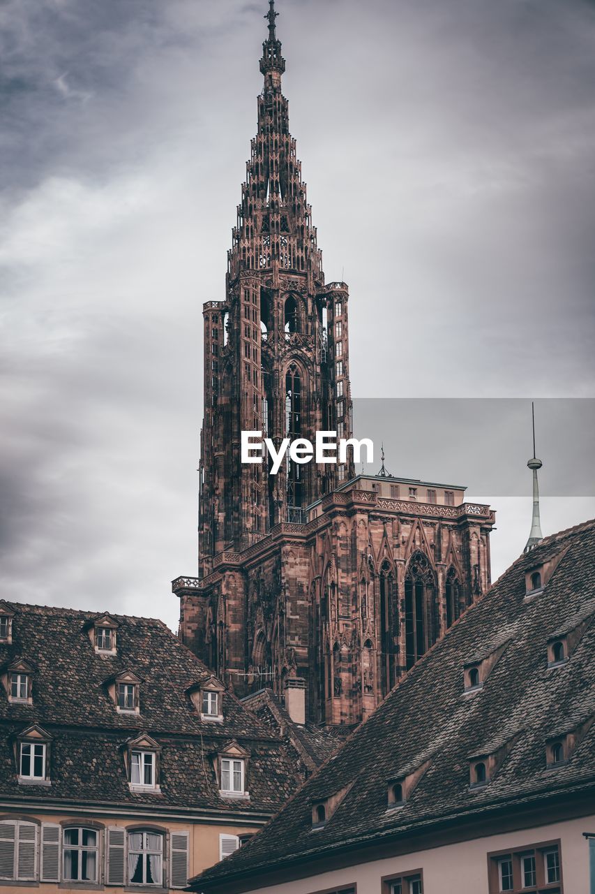 architecture, built structure, building exterior, building, travel destinations, tower, landmark, sky, spire, city, history, cloud, the past, religion, travel, place of worship, worship, tourism, nature, cityscape, belief, low angle view, no people, spirituality, urban area, outdoors, steeple, gothic style, clock tower, old, facade, business finance and industry