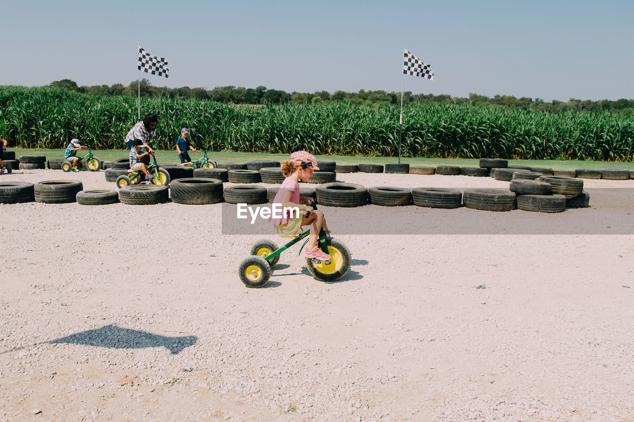 Girl riding tricycle on field