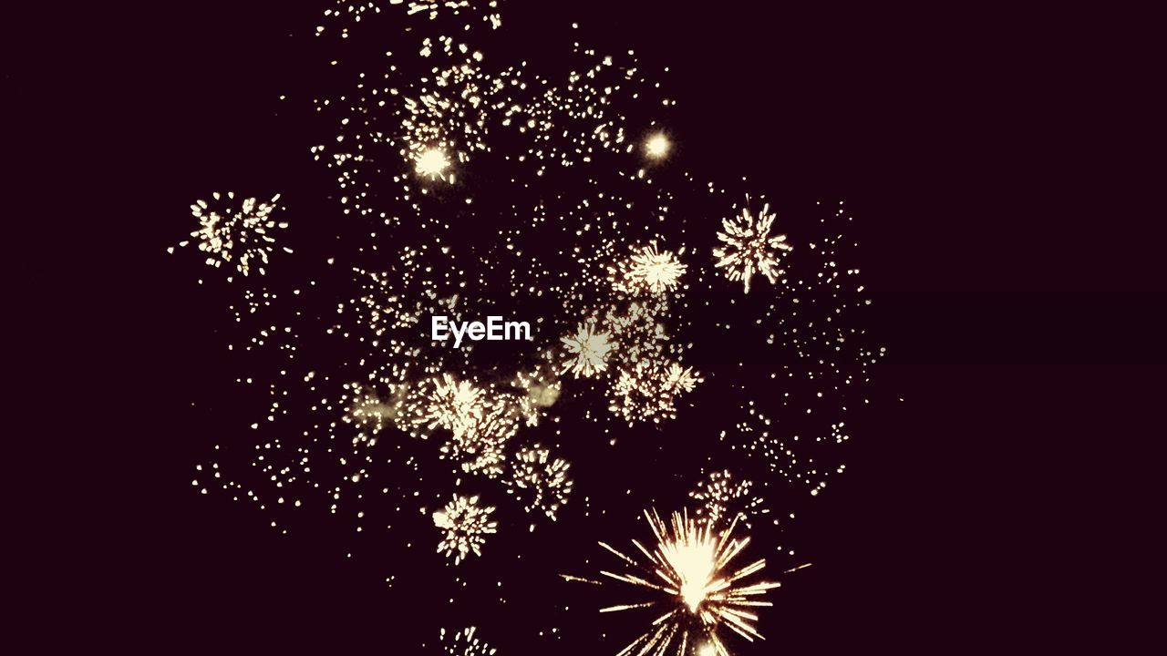 Low angle view of firework display at night