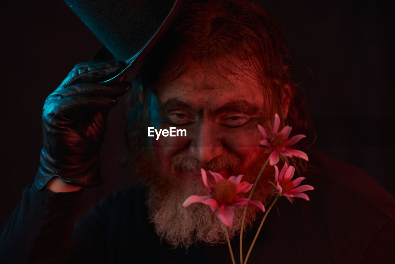 one person, portrait, adult, headshot, darkness, flower, red, facial hair, black background, beard, studio shot, flowering plant, men, indoors, emotion, redhead, human face, nature, person, looking at camera, beauty in nature, close-up, plant, dark