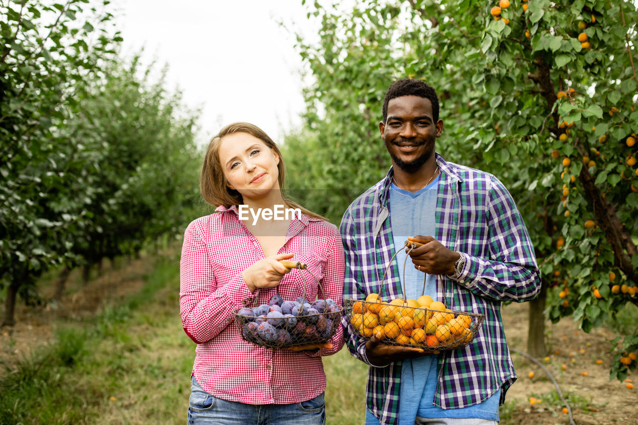 Happy young man having food against plants