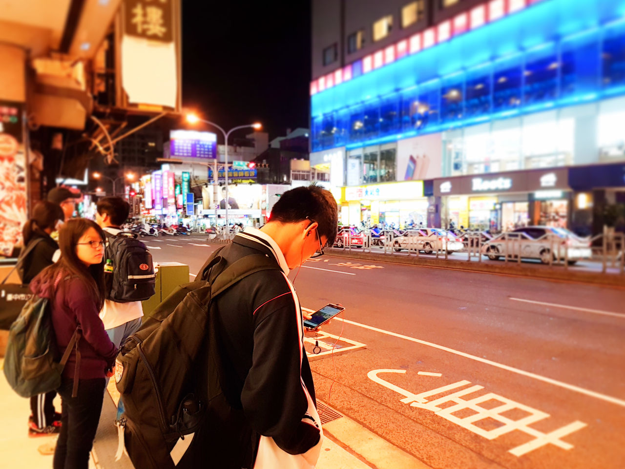 Nowadays, people are oftentimes engrossed in their phones rather than the outside world The Street Photographer - 2018 EyeEm Awards Architecture Building Exterior Built Structure City City Life City Street Communication Group Of People Illuminated Lifestyles Men Night Outdoors People Real People Road Sign Street Text Transportation Women The Traveler - 2018 EyeEm Awards